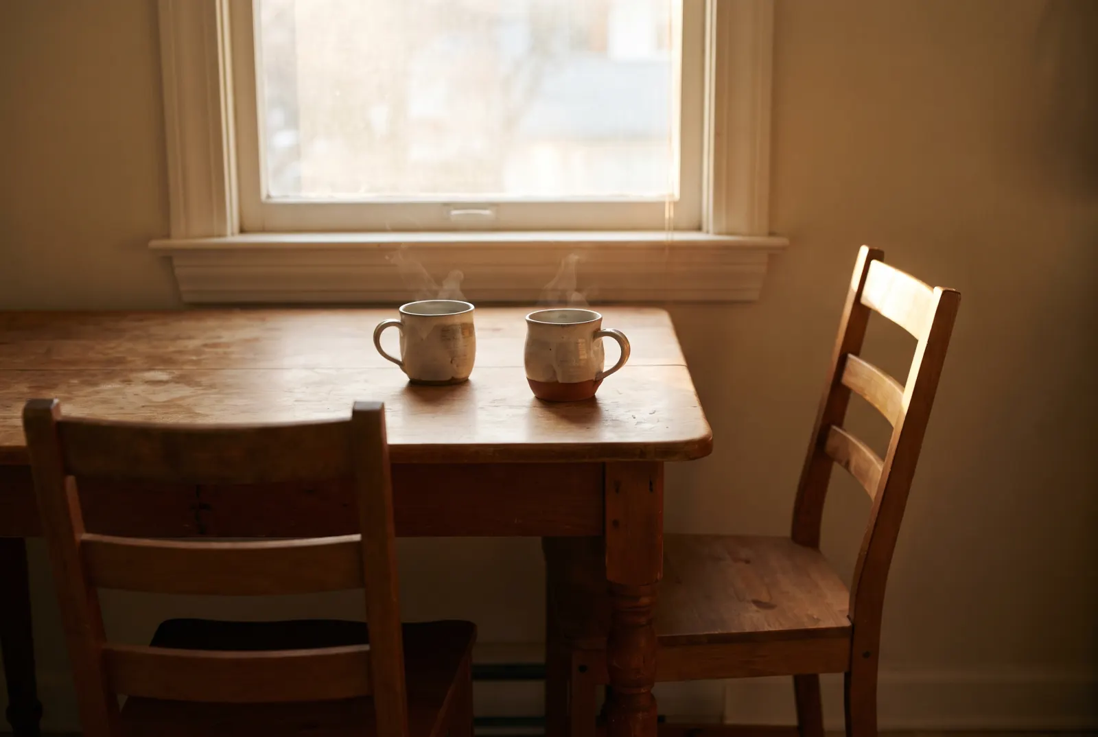 Two cups of tea on a small table with two chairs